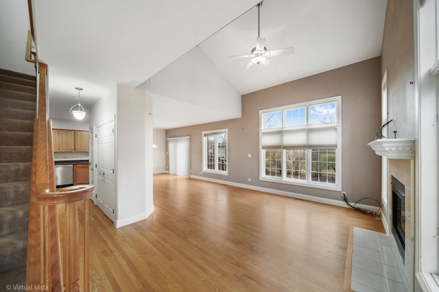 unfurnished living room with light hardwood / wood-style floors, high vaulted ceiling, and ceiling fan