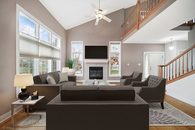 living room with high vaulted ceiling, wood-type flooring, and a wealth of natural light