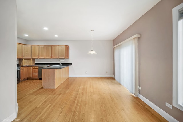 kitchen with a kitchen breakfast bar, light wood-type flooring, decorative light fixtures, kitchen peninsula, and stainless steel appliances