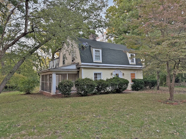 view of front facade featuring a front yard and a sunroom