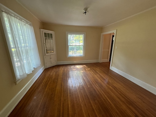 unfurnished room with dark hardwood / wood-style flooring and crown molding