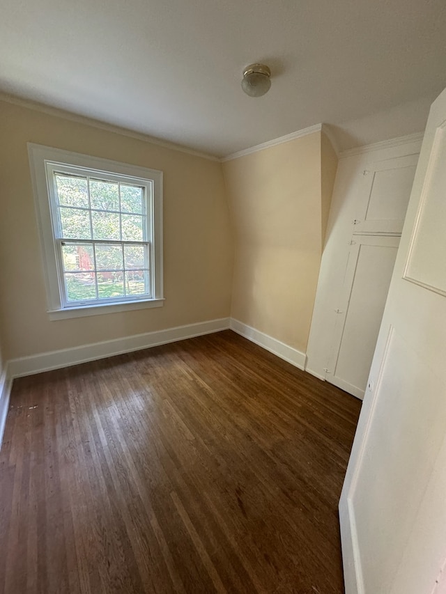 empty room featuring dark hardwood / wood-style flooring and ornamental molding