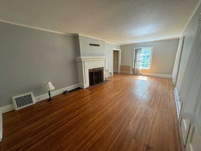 unfurnished living room with crown molding and hardwood / wood-style flooring