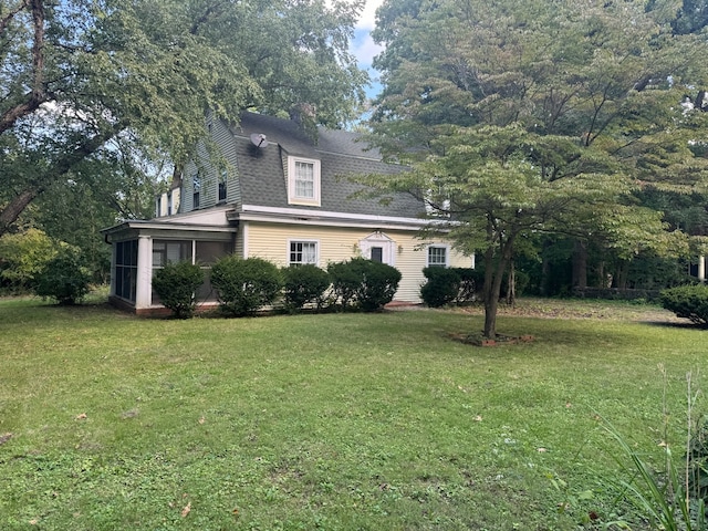 view of front facade featuring a front yard and a sunroom