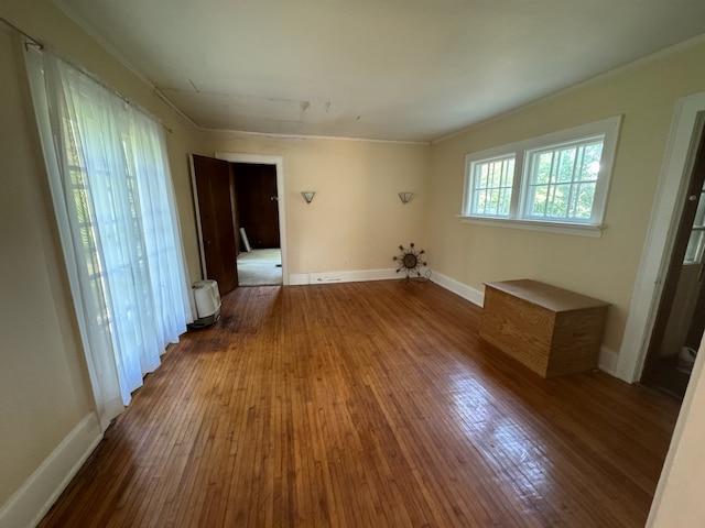 empty room with hardwood / wood-style flooring and ornamental molding