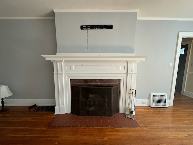 room details with a fireplace, ornamental molding, and hardwood / wood-style flooring