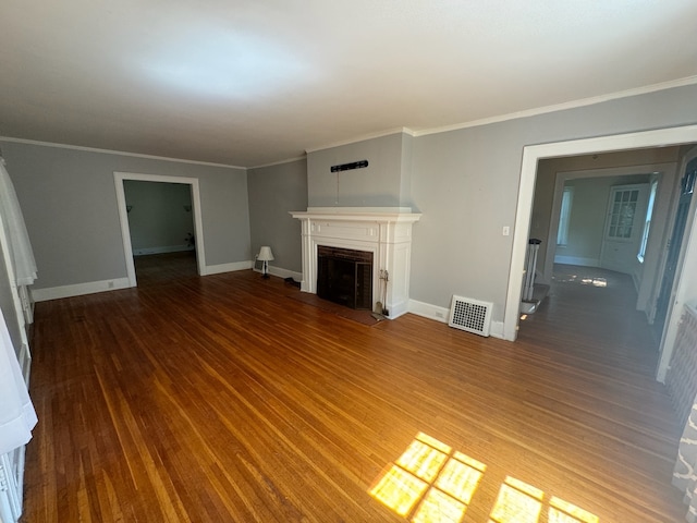 unfurnished living room featuring dark hardwood / wood-style flooring and ornamental molding