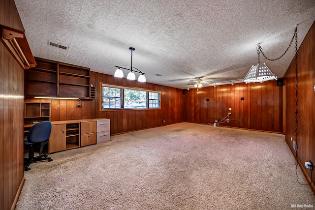 unfurnished office featuring ceiling fan, carpet floors, and a textured ceiling