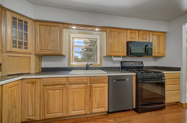 kitchen featuring sink, light hardwood / wood-style floors, and black appliances