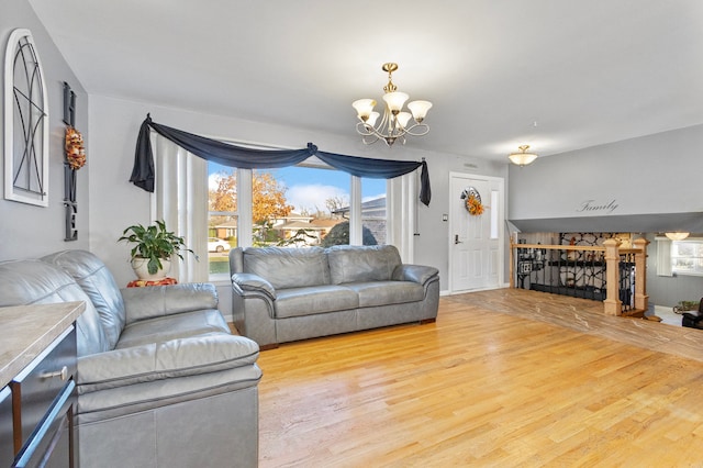 living room featuring a notable chandelier and light wood-type flooring