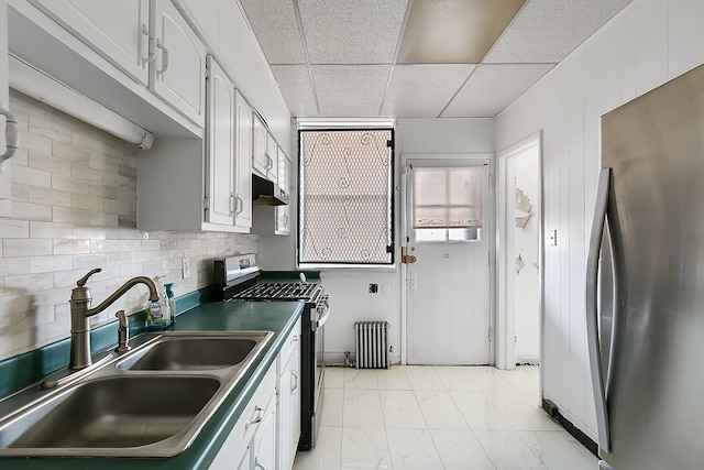 kitchen featuring a drop ceiling, white cabinets, sink, decorative backsplash, and stainless steel appliances