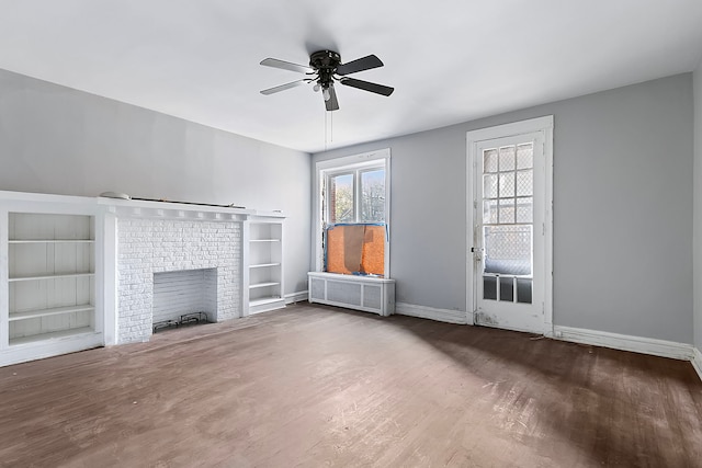 unfurnished living room featuring wood-type flooring, a brick fireplace, ceiling fan, and radiator