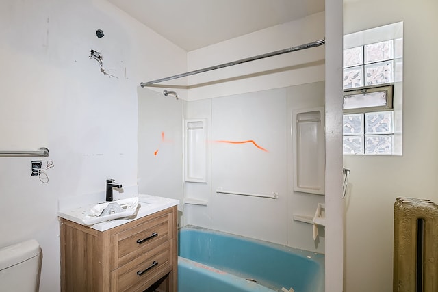 full bathroom featuring washtub / shower combination, radiator heating unit, vanity, and toilet