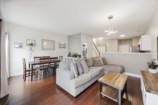 living room with a chandelier and dark wood-type flooring