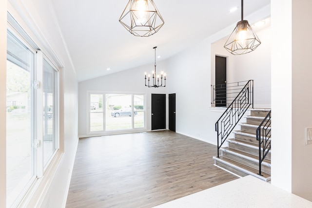 entrance foyer featuring a chandelier, wood-type flooring, and vaulted ceiling