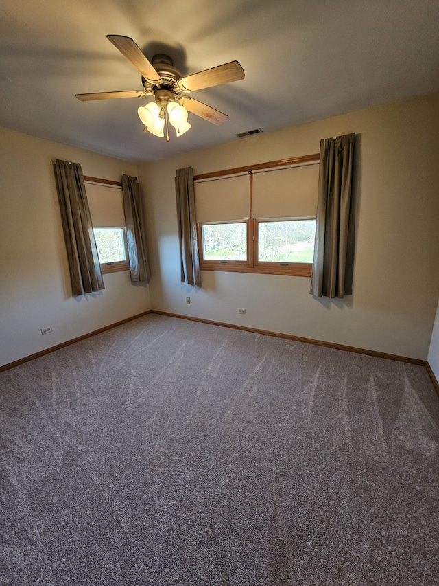 carpeted spare room featuring ceiling fan