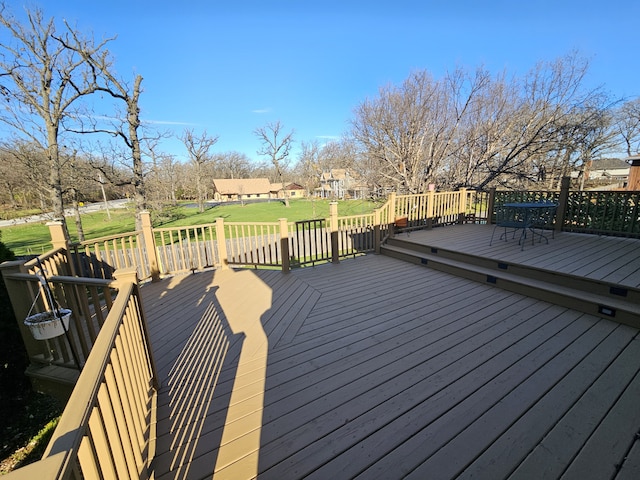 wooden terrace featuring a lawn