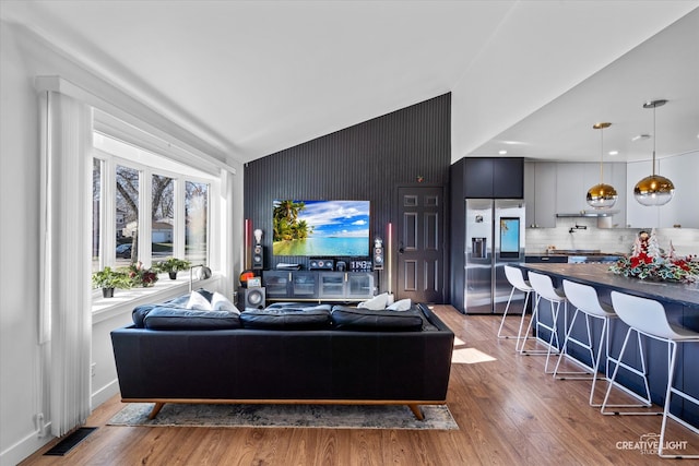 living room with hardwood / wood-style floors and lofted ceiling