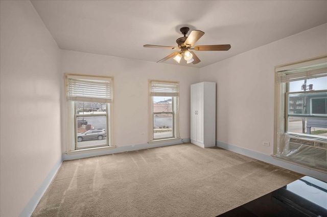 carpeted empty room featuring ceiling fan