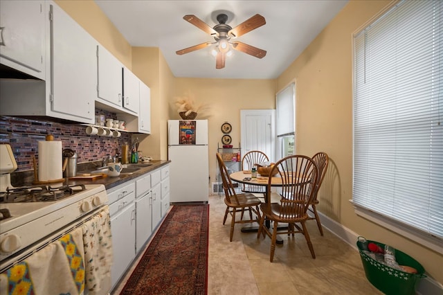 kitchen with ceiling fan, tasteful backsplash, light tile patterned flooring, white appliances, and white cabinets