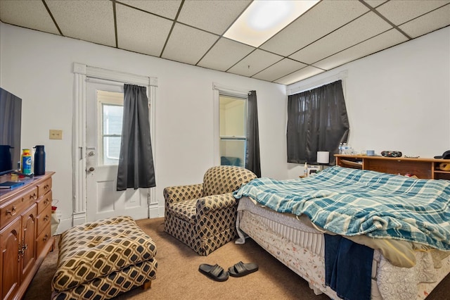 carpeted bedroom with a drop ceiling