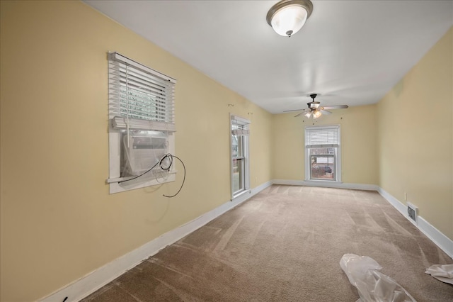 carpeted spare room with ceiling fan