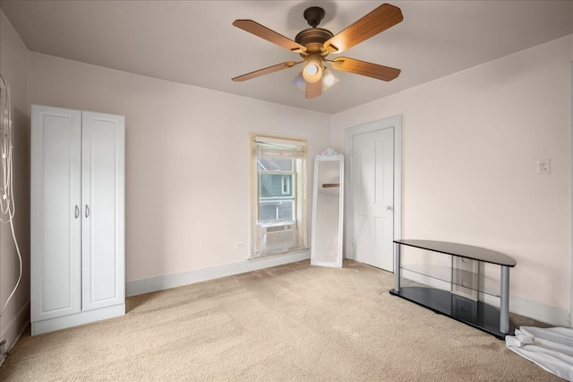 unfurnished bedroom with ceiling fan, cooling unit, and light carpet