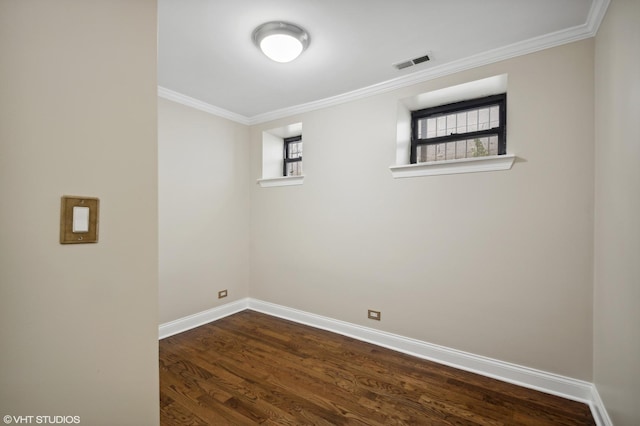 empty room with dark hardwood / wood-style flooring and crown molding