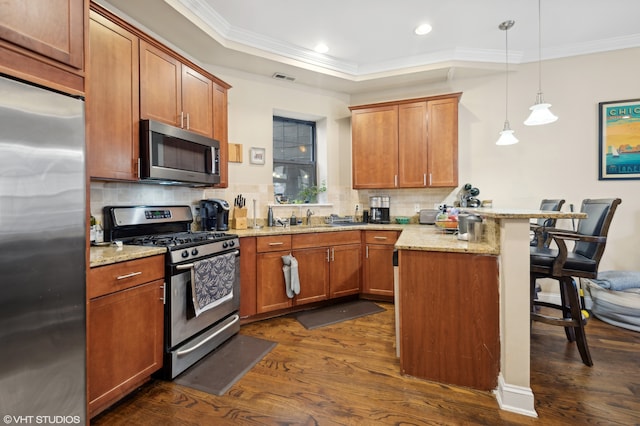 kitchen featuring kitchen peninsula, a breakfast bar, stainless steel appliances, dark hardwood / wood-style floors, and hanging light fixtures