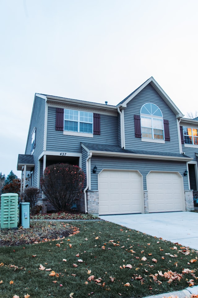 view of front of house featuring a garage and a front lawn