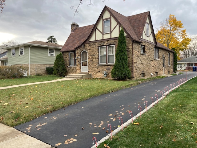 english style home with a front yard