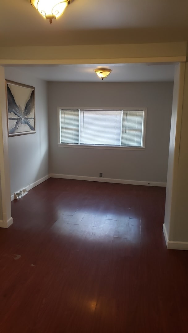 unfurnished room featuring dark wood-type flooring