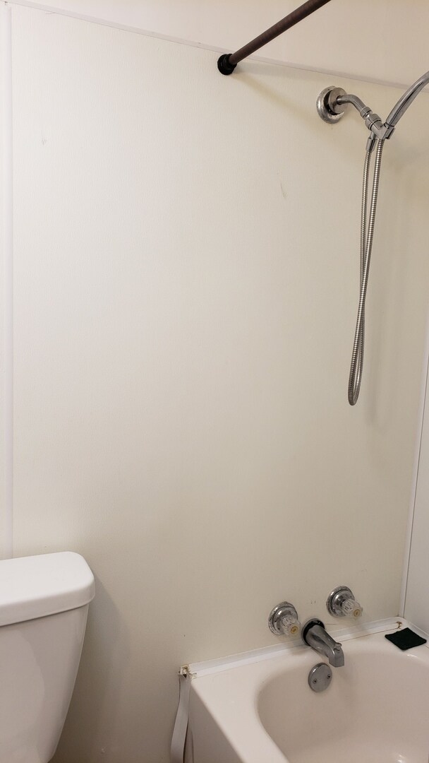 bathroom with toilet and bathtub / shower combination