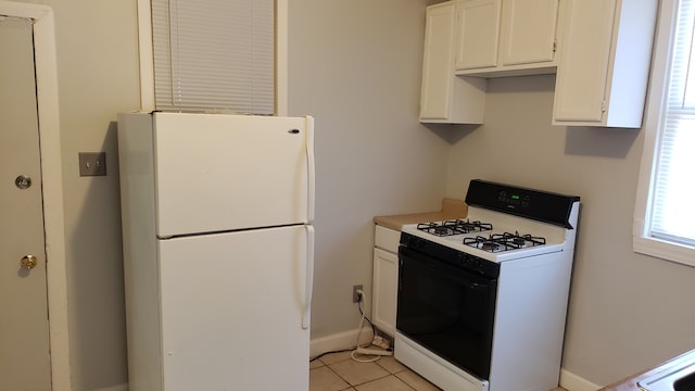 kitchen featuring light tile patterned floors, white appliances, and white cabinetry