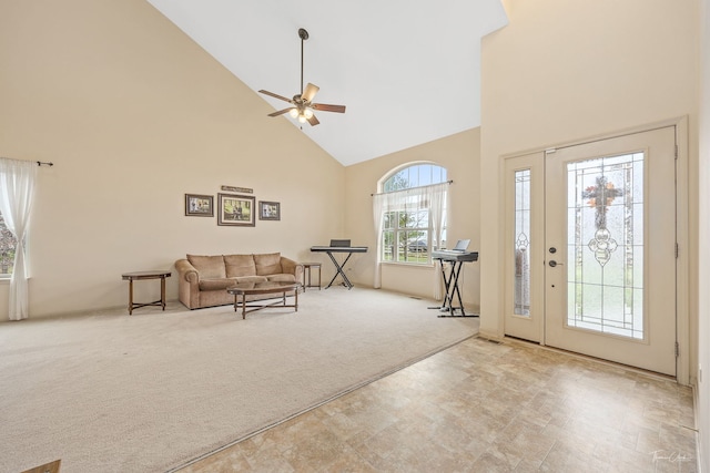 carpeted entryway featuring ceiling fan and high vaulted ceiling