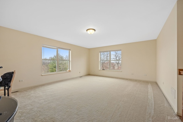 spare room featuring light colored carpet