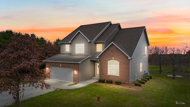 view of front of house with a garage, a yard, and central air condition unit