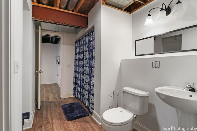 bathroom with wood-type flooring, toilet, a shower with curtain, and sink