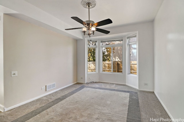 spare room featuring light carpet and ceiling fan