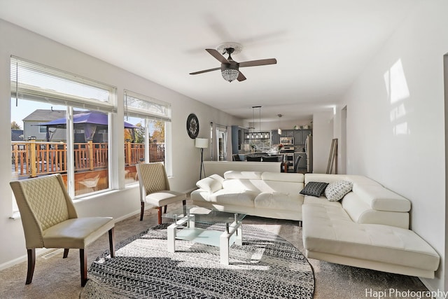 carpeted living room with ceiling fan