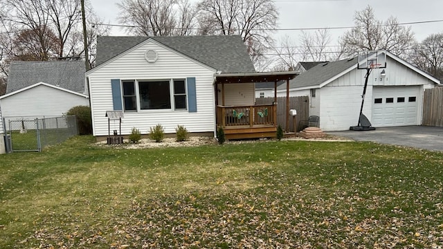 view of front of home featuring a front yard, covered porch, an outdoor structure, and a garage