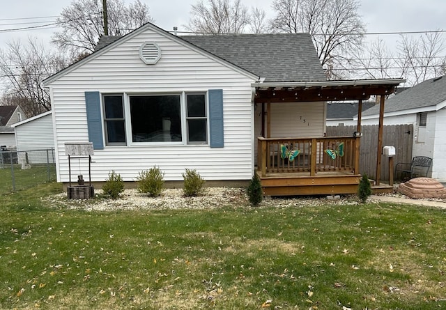 rear view of property with a lawn and a deck