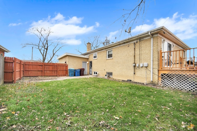 rear view of house featuring a lawn and a wooden deck