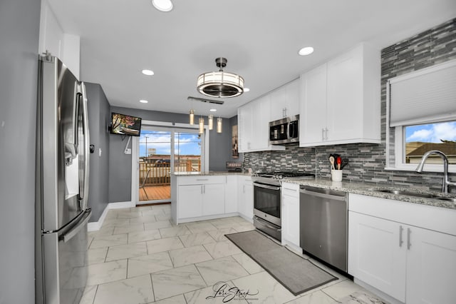 kitchen featuring a wealth of natural light, white cabinets, and stainless steel appliances