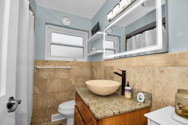 bathroom featuring tile patterned flooring, vanity, tile walls, and toilet