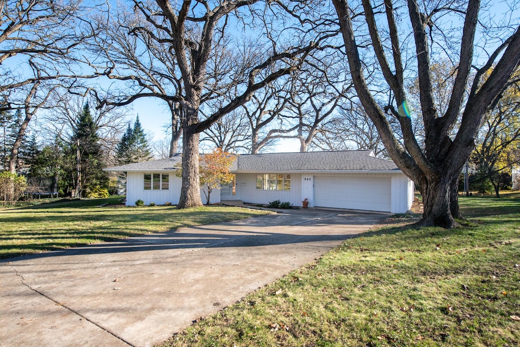 single story home featuring a garage and a front lawn