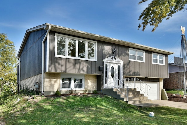 split foyer home with a garage and a front yard