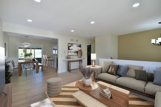 living room with light hardwood / wood-style flooring and a notable chandelier