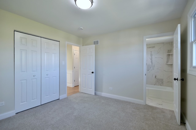 unfurnished bedroom featuring light carpet and a closet