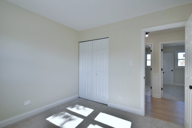 unfurnished bedroom with light wood-type flooring and a closet